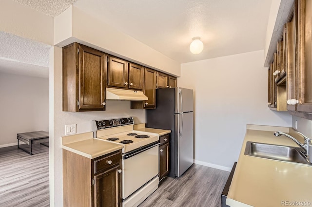 kitchen featuring a textured ceiling, white electric range oven, wood-type flooring, and sink