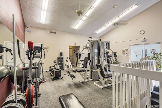 gym featuring a textured ceiling, vaulted ceiling, and ceiling fan