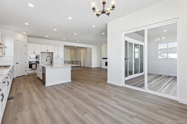 kitchen with decorative light fixtures, sink, a notable chandelier, and stainless steel appliances