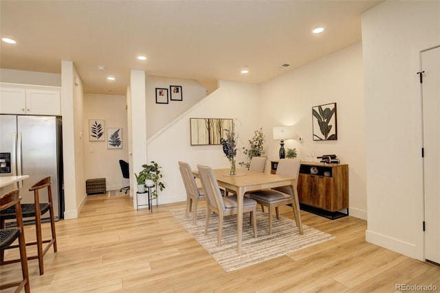 dining room with stairway, light wood-style floors, recessed lighting, and baseboards