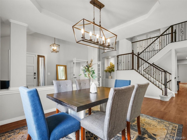 9464 E Aspen Hill Pl, Lone Tree, CO 80124 - dining area featuring a tray ceiling, wood finished floors, a chandelier, stairs, and a towering ceiling
