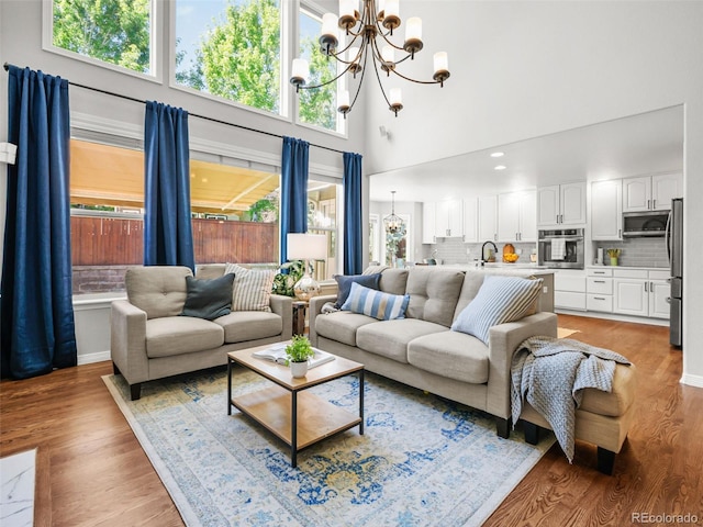 9464 E Aspen Hill Pl, Lone Tree, CO 80124 - living room with a chandelier, a high ceiling, and light wood-type flooring