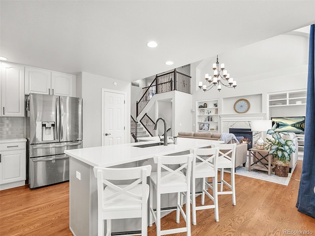 9464 E Aspen Hill Pl, Lone Tree, CO 80124 - kitchen featuring stainless steel fridge with ice dispenser, light wood-style floors, white cabinetry, a kitchen breakfast bar, and recessed lighting