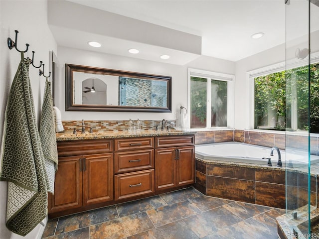 9464 E Aspen Hill Pl, Lone Tree, CO 80124 - full bathroom featuring double vanity, a bath, stone tile flooring, and recessed lighting