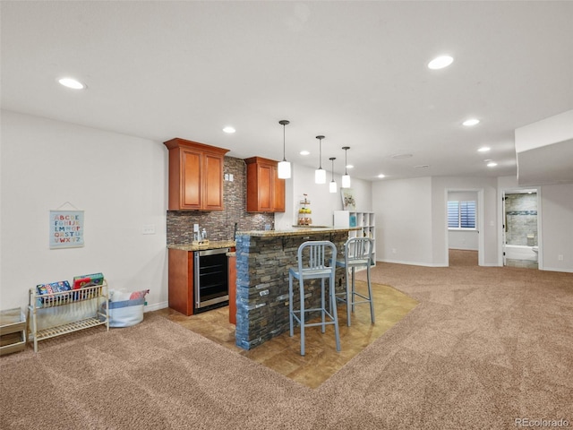 9464 E Aspen Hill Pl, Lone Tree, CO 80124 - kitchen with beverage cooler, brown cabinets, a breakfast bar area, recessed lighting, and light carpet