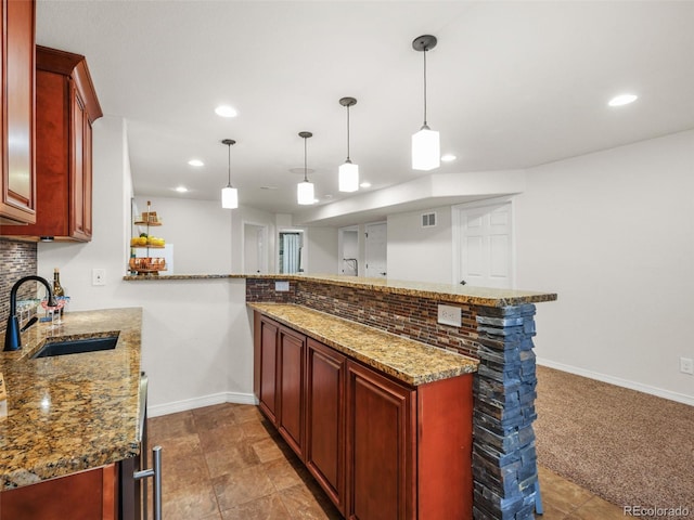 9464 E Aspen Hill Pl, Lone Tree, CO 80124 - kitchen featuring reddish brown cabinets, recessed lighting, a peninsula, decorative backsplash, and stone counters