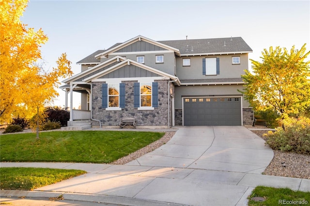 craftsman house with an attached garage, driveway, stone siding, board and batten siding, and a front yard