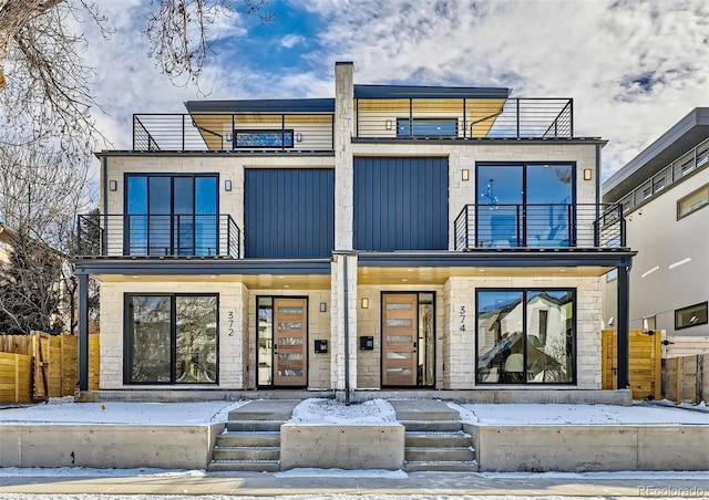 view of front of house featuring fence and a balcony