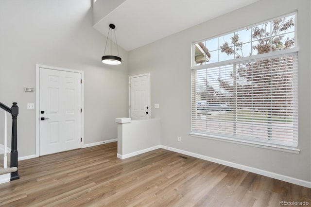 foyer with high vaulted ceiling and hardwood / wood-style floors