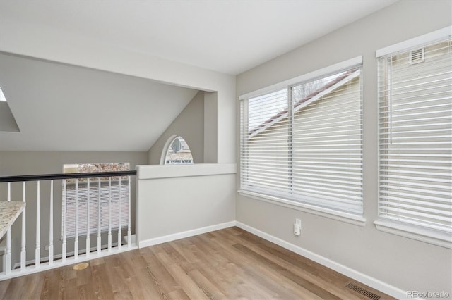 unfurnished room with light hardwood / wood-style flooring and vaulted ceiling