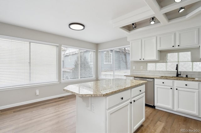 kitchen with sink, white cabinets, a center island, light hardwood / wood-style flooring, and stainless steel dishwasher