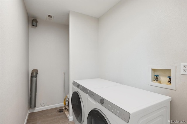 clothes washing area featuring light hardwood / wood-style floors and hookup for a washing machine