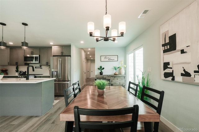 1450 Syracuse St, Denver, CO 80220 - dining area featuring light wood finished floors, a chandelier, recessed lighting, and baseboards