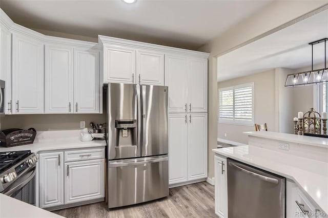 kitchen with light countertops, light wood-style floors, stainless steel appliances, and white cabinetry