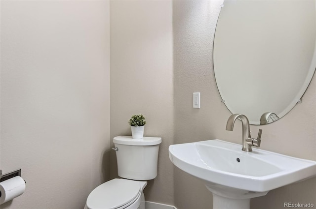 half bath featuring a sink and toilet