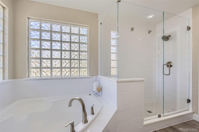 bathroom with a shower stall and a garden tub