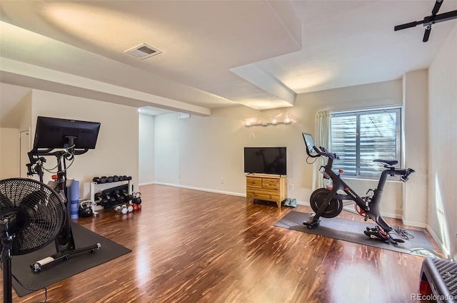 workout area featuring visible vents, baseboards, and wood finished floors