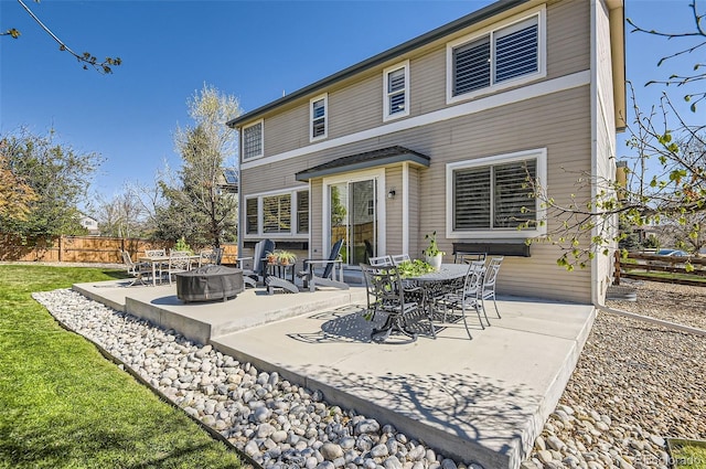 rear view of property with a patio, an outdoor fire pit, fence, and a yard