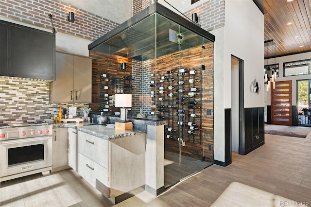 wine area featuring a towering ceiling, wooden ceiling, and light wood-style flooring