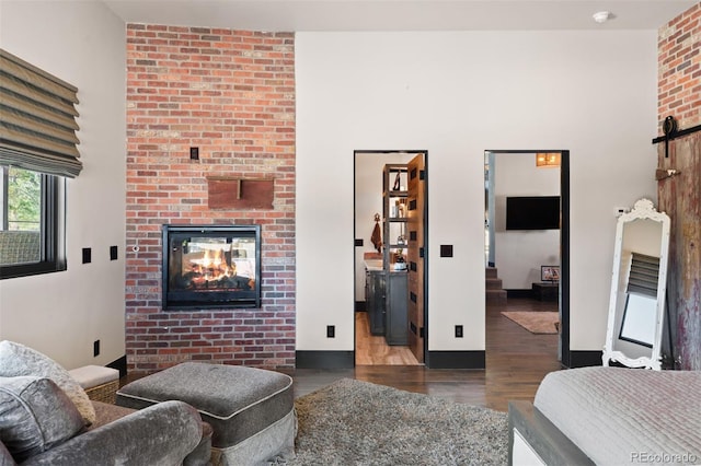 bedroom featuring a fireplace, wood finished floors, and baseboards