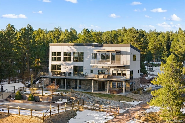 rear view of property featuring a patio and a balcony