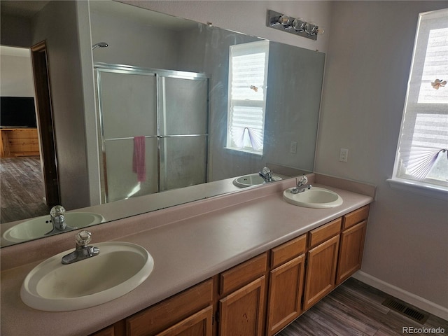 bathroom featuring vanity, hardwood / wood-style floors, and a shower with shower door