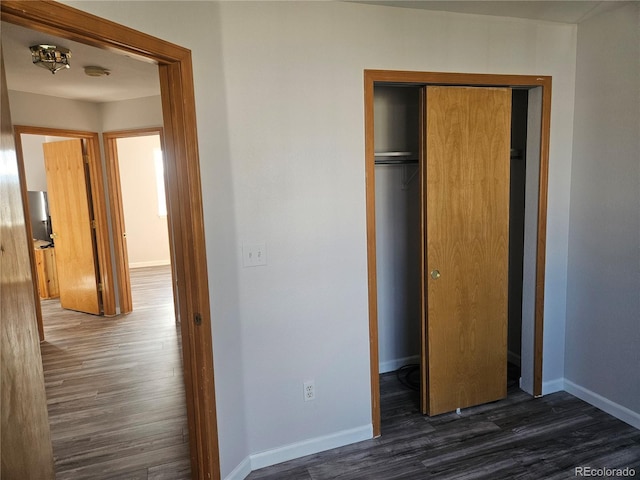 unfurnished bedroom with dark hardwood / wood-style flooring and a closet