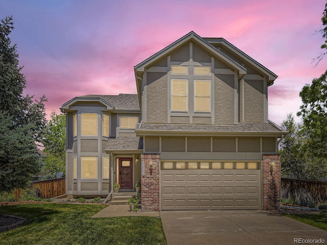 traditional home with a garage, stucco siding, concrete driveway, brick siding, and roof with shingles