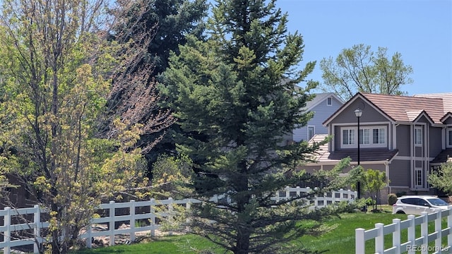 view of side of property with fence and a tiled roof