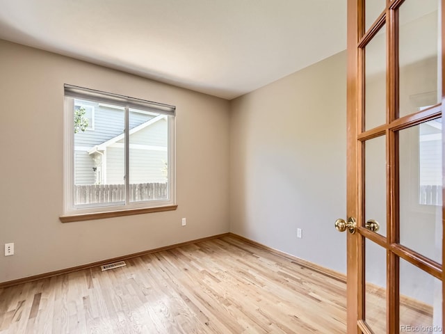unfurnished room with light wood finished floors and baseboards