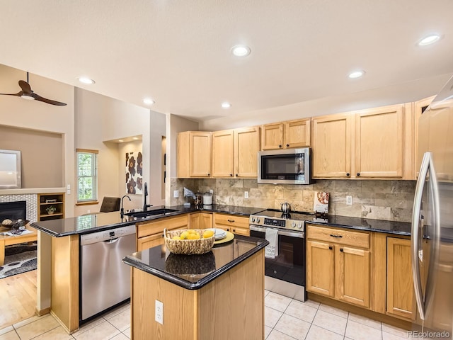 kitchen with stainless steel appliances, a sink, light brown cabinets, a peninsula, and ceiling fan