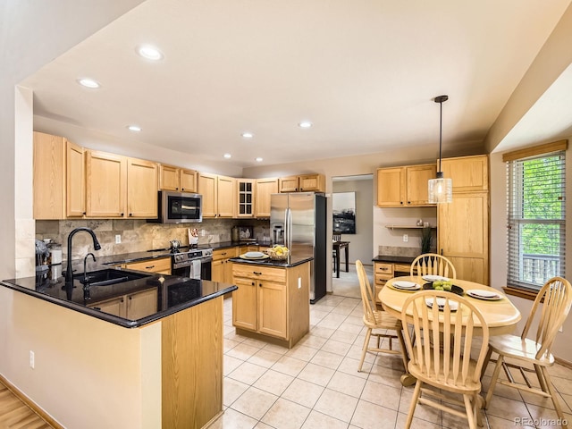 kitchen with a sink, stainless steel appliances, light brown cabinets, and recessed lighting