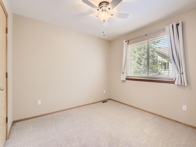 empty room with light colored carpet, baseboards, and ceiling fan