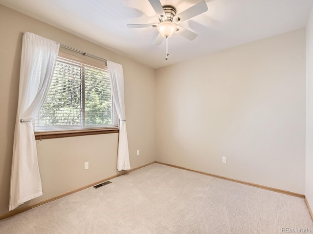 empty room featuring light carpet, baseboards, and a ceiling fan