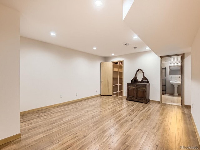 unfurnished living room with light wood finished floors, recessed lighting, and baseboards