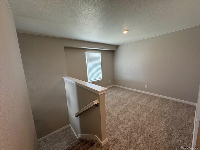 empty room featuring carpet and a textured ceiling