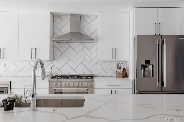 1322 Raleigh St, Denver, CO 80204 - kitchen featuring backsplash, white cabinetry, wall chimney exhaust hood, and stainless steel appliances