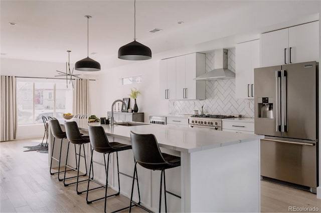 1322 Raleigh St, Denver, CO 80204 - kitchen with tasteful backsplash, wall chimney range hood, visible vents, a sink, and stainless steel appliances