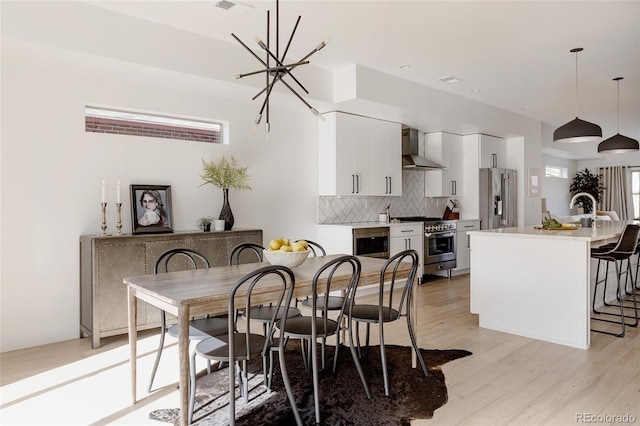 1322 Raleigh St, Denver, CO 80204 - dining area with light wood finished floors and an inviting chandelier