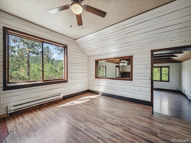 366 Houston St, Bailey, CO 80421 - unfurnished room featuring a baseboard heating unit, lofted ceiling, a ceiling fan, wood walls, and wood finished floors