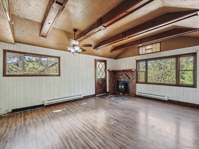366 Houston St, Bailey, CO 80421 - unfurnished living room featuring baseboard heating, ceiling fan, wood finished floors, healthy amount of natural light, and wooden walls