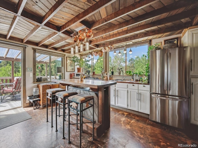 366 Houston St, Bailey, CO 80421 - kitchen featuring freestanding refrigerator, a sink, white cabinets, wood ceiling, and beam ceiling
