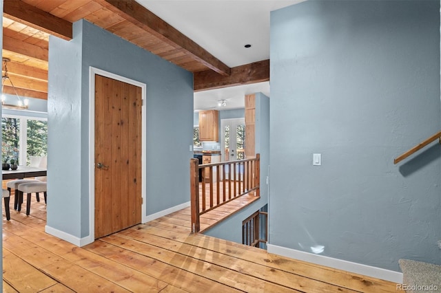 interior space with beam ceiling, wood ceiling, and light hardwood / wood-style floors