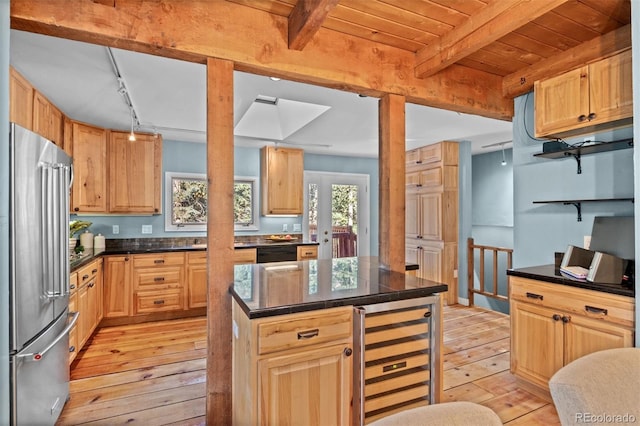 kitchen featuring high end refrigerator, light wood-type flooring, a kitchen island, beam ceiling, and wine cooler