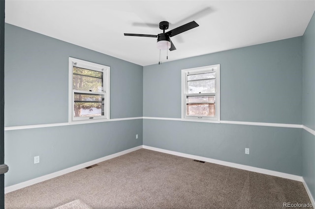 carpeted spare room with ceiling fan and a healthy amount of sunlight