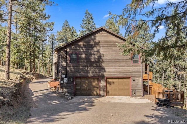 view of property exterior with a garage and a wooden deck