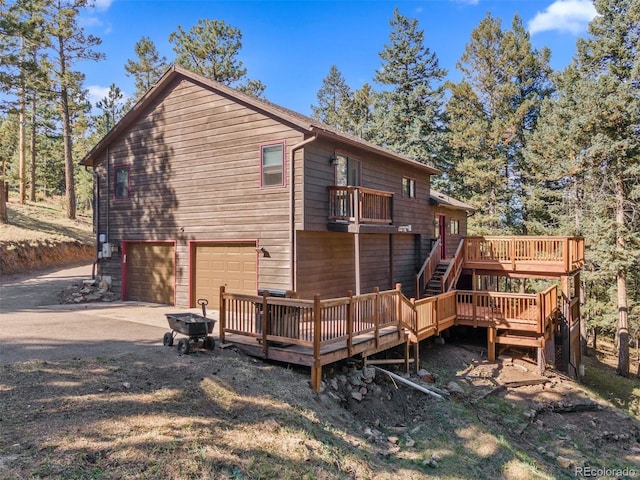 rear view of house with a garage and a wooden deck