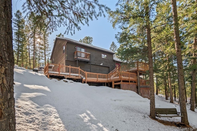 rear view of house featuring a balcony and a deck