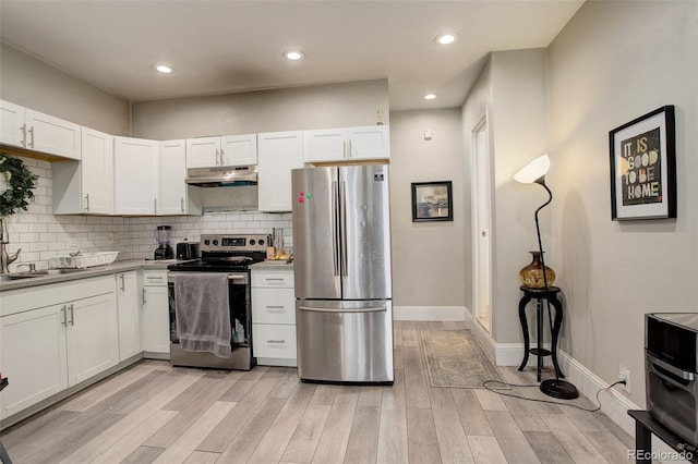 841 Crisman Dr Unit 9, Longmont, CO 80501 - kitchen featuring stainless steel appliances, under cabinet range hood, white cabinetry, light wood finished floors, and tasteful backsplash