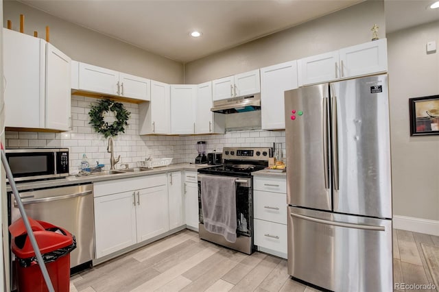 841 Crisman Dr Unit 9, Longmont, CO 80501 - kitchen featuring appliances with stainless steel finishes, under cabinet range hood, light countertops, white cabinetry, and recessed lighting